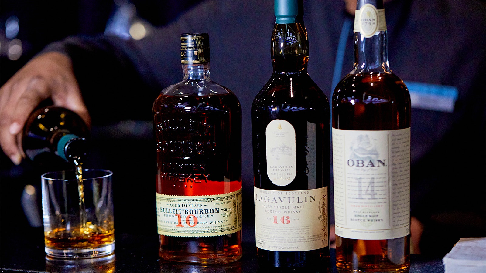 Bottles of Oban 14, Lagavulin16 and Bulleit 10 alongside a glass of whisky at the 2024 New York Wine Experience Champagne Reception